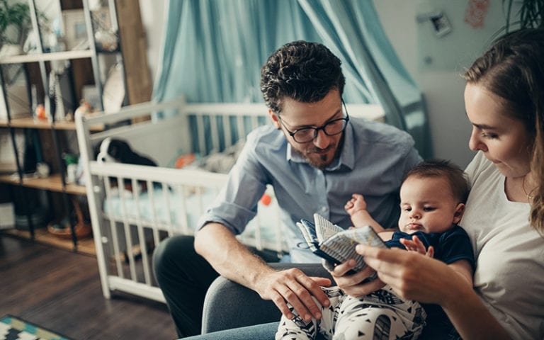 Mom and dad reading to baby boy