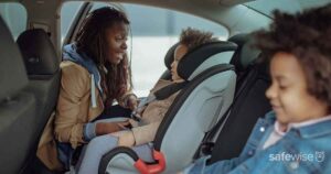 car seat with mother buckling in young daughter