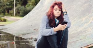 teenager texting at skate park