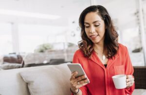 woman in pink shirt checks her phone