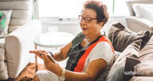 senior-sitting-on-couch-using-device