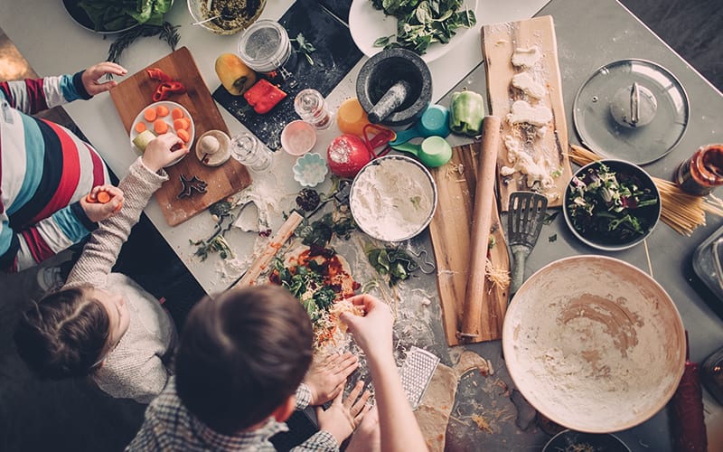 kids and mom making pizza in kitchen